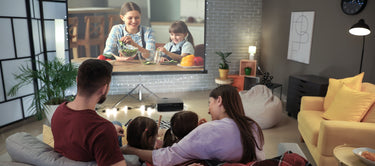 Family enjoying a cooking show in a modern, cozy living room.